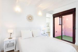 Un dormitorio blanco con una cama blanca y una ventana en Ático. Vistas al mar y montaña., en Arafo