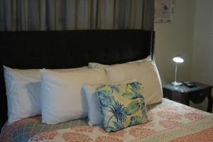 a bed with white pillows and a black headboard at Casa Blanca Casita by the Ocean in St. Augustine