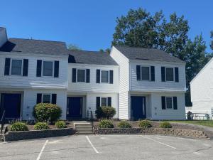 艾斯沃茲的住宿－Acadia Village Resort，停车场内有蓝色门的白色房子
