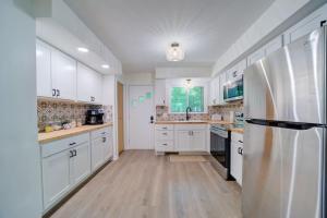 a kitchen with white cabinets and a stainless steel refrigerator at Scenic Drive Resort in Muskegon