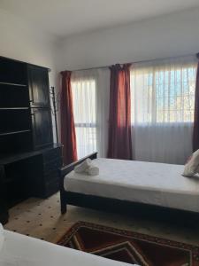 1 Schlafzimmer mit 2 Betten und 2 Fenstern in der Unterkunft AZAWAN HOUSE in Tamraght Ouzdar