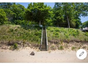 a stairway leading up to a sandy beach with a stairway at Scenic Drive Resort in Muskegon