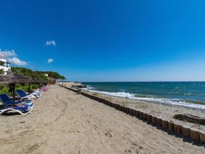une plage avec des chaises et des parasols et l'océan dans l'établissement Casa Emma les pieds dans l'eau, à San-Nicolao 2 autres photos