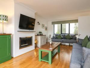 a living room with a couch and a fireplace at Ash Tree House in Salcombe