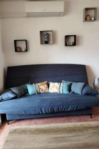 a blue couch with pillows on it in a room at Casa Emma les pieds dans l'eau in San-Nicolao