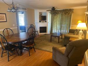 a living room with a table and a dining room at Acadia Village Resort in Ellsworth