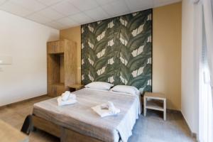 1 Schlafzimmer mit 2 Betten und Wandgemälde in der Unterkunft Affittacamere Flavia Roma in Ostia Antica