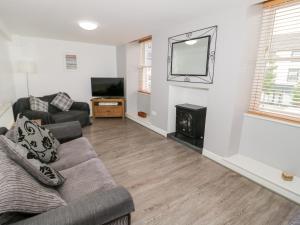 a living room with a couch and a flat screen tv at Hand Apartment in Llanrwst