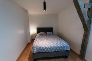 sypialnia z łóżkiem w białym pokoju w obiekcie Appartement de Romain w mieście Charleville-Mézières