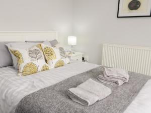 1 cama con 2 toallas y almohadas en Hand Apartment, en Llanrwst