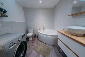La salle de bains est pourvue d'un lave-linge et d'un lavabo. dans l'établissement Appartement de Romain, à Charleville-Mézières