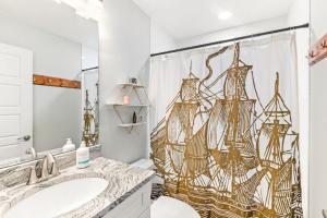 a bathroom with a shower curtain with a pirate ship shower curtain at Safar by the Sea in Davis Shores in St. Augustine