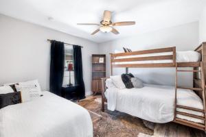 a bedroom with two bunk beds and a ceiling fan at Safar by the Sea in Davis Shores in Saint Augustine