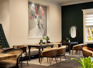 a restaurant with tables and chairs and a painting on the wall at The Steward, Santa Barbara, a Tribute Portfolio Hotel in Santa Barbara