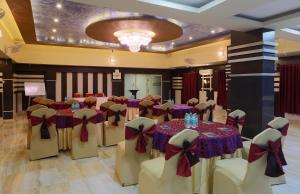 um salão de banquetes com mesas e cadeiras com arcos em Hotel Blue Bird, Nagaon em Nowgong