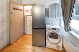 eine Küche mit einer Waschmaschine und einem Kühlschrank in der Unterkunft L'élégant-Parking privé-10min strasbourg-NBSimmo in Bischheim