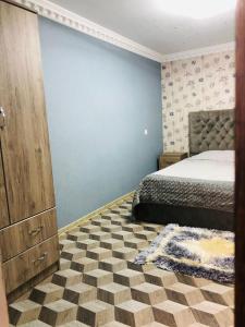 - une chambre avec un lit et un mur bleu dans l'établissement RADENO HOUSE, à Tbilissi