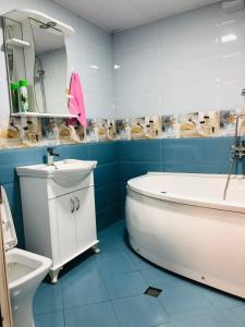 La salle de bains est pourvue d'une baignoire, d'un lavabo et de toilettes. dans l'établissement RADENO HOUSE, à Tbilissi