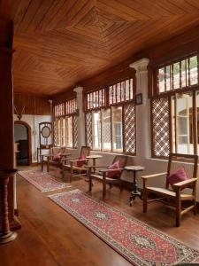 a living room with tables and chairs and windows at Elpitiya Walauwa Heritage Home in Gampola