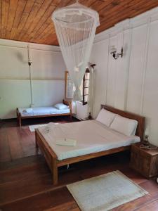 a bedroom with a large bed and a wooden ceiling at Elpitiya Walauwa Heritage Home in Gampola