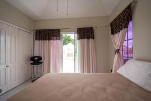 a bedroom with a large bed and a window at JAG Guesthouse- Little Bay Country Club in Negril