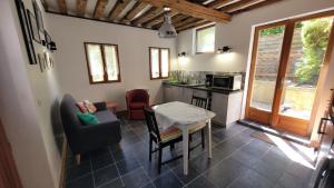 a kitchen and living room with a table and chairs at Le Jardin des Murmures in Honfleur