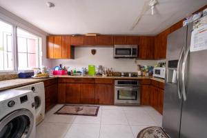 a kitchen with a stainless steel refrigerator and a dishwasher at JAG Guesthouse- Little Bay Country Club in Negril