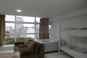 een kamer met een bank, een bed en een raam bij Best View 1413 in Sao Paulo