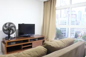 een woonkamer met een bank en een flatscreen-tv bij Best View 1413 in Sao Paulo