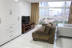 een woonkamer met een bank en een tv bij Best View 1413 in Sao Paulo
