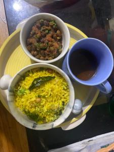 a table with two bowls of food and a cup of coffee at Couzy Cocoonn Stays in Nagpur