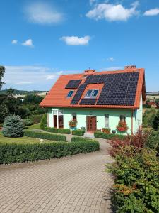 Dom Na Skarpie في فالبرزيخ: منزل على السطح مع لوحات شمسية