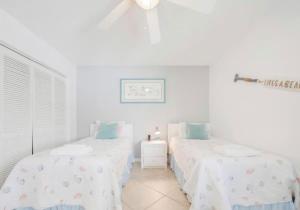 two twin beds in a room with white walls at Oasis 21 Oceanfront with Pool in Saint Augustine +32 photos