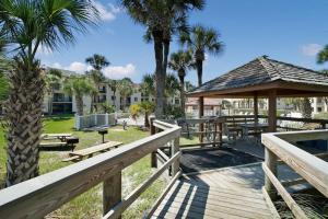 um deque com mesas de piquenique e um gazebo em Oasis 21 Oceanfront with Pool em Saint Augustine
