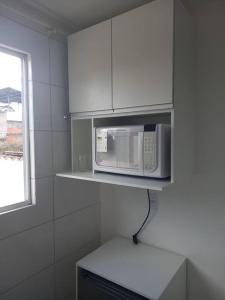 a microwave on a shelf in a kitchen at Apartamento Vila Telebrasilia in Brasília