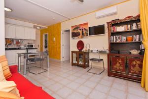a living room with a red couch and a kitchen at Penthouse El Mirador Los Cristianos Tenerife - VV in Los Cristianos