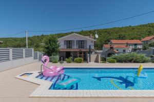 a swimming pool with a pink pelicans and a swimming pool at Spacious villa for 10 with a big private pool in Trilj