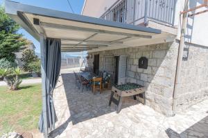 awning over a patio with a table and chairs at Spacious villa for 10 with a big private pool in Trilj
