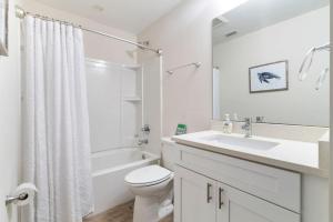 a white bathroom with a sink and a toilet at Treehouse By the Sea in St. Augustine +43 photos