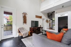 a living room with a gray couch and a television at Whitefish Lodge in St. Augustine