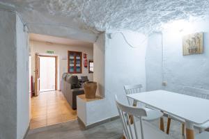 una sala de estar con una mesa y un sofá en Casa cueva El establo del Júcar, en Alcalá del Júcar