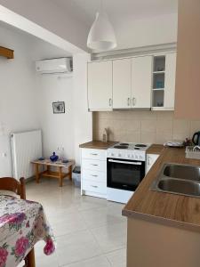 a kitchen with a sink and a stove top oven at Kate House in Áyioi Apóstoloi