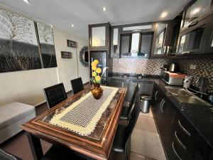 a kitchen with a wooden table with chairs and a sink at The Regency Tanjung Tuan Beach Resort Port Dickson in Port Dickson