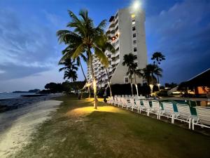 a hotel on the beach with a palm tree and a building at The Regency Tanjung Tuan Beach Resort Port Dickson in Port Dickson