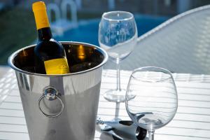 a bucket of wine sitting on a table with wine glasses at 4Ever Palace - Design & Nature in Alcácer do Sal