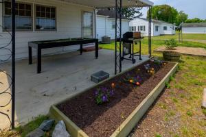 un jardín con una mesa de ping pong y flores en The CrackerJack House: A Military Salute & Arcade!, en Surry