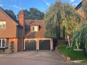a house with a garage and a tree at Beautiful Annex Apartment with off street parking in Potters Bar