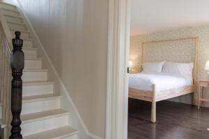 a bedroom with a bed and a stair case at Russelltown Inn in Bonavista