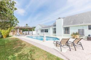 une maison avec une piscine et des chaises dans la cour dans l'établissement 23rd St Salty Pirate, à Saint Augustine