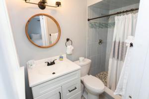 a bathroom with a sink and a toilet and a mirror at Captains Quarters Island location Hot tub One Level in Saint Augustine